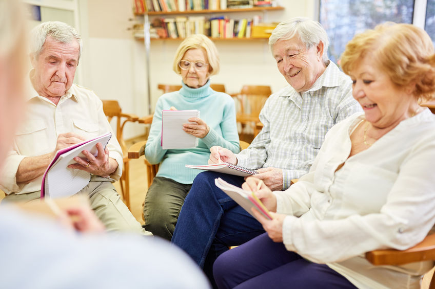 Seniors in group therapy while writing